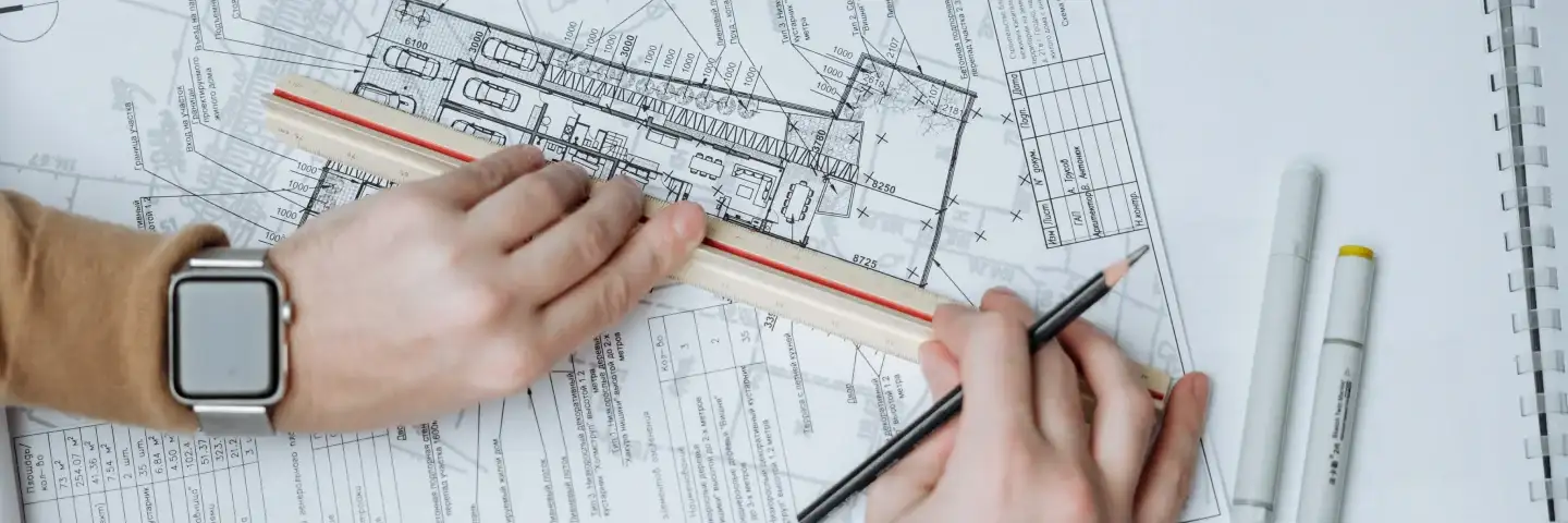 Man sketching an arhitectural blueprint on a piece of paper